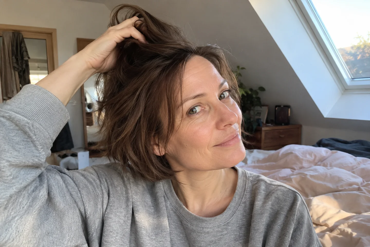 Une femme soulève légèrement ses racines avec les doigts