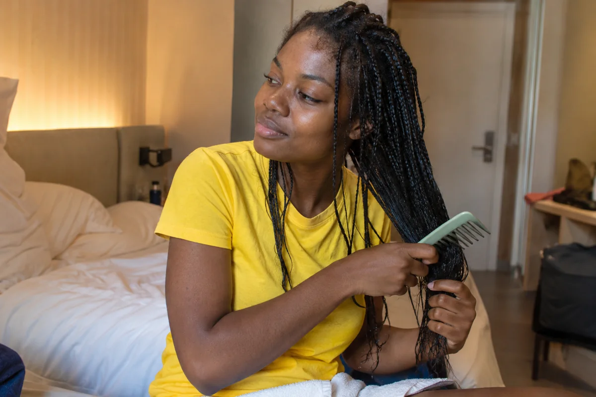 Une femme démêle délicatement les extrémités de ses cheveux
