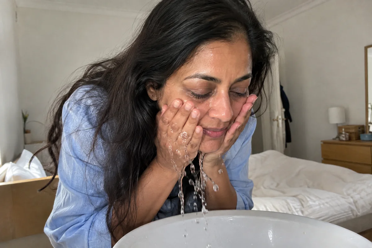 Rinçage doux du visage au-dessus du lavabo