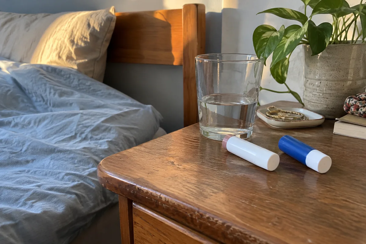 Des baumes fermés et un verre d’eau sur une table de nuit