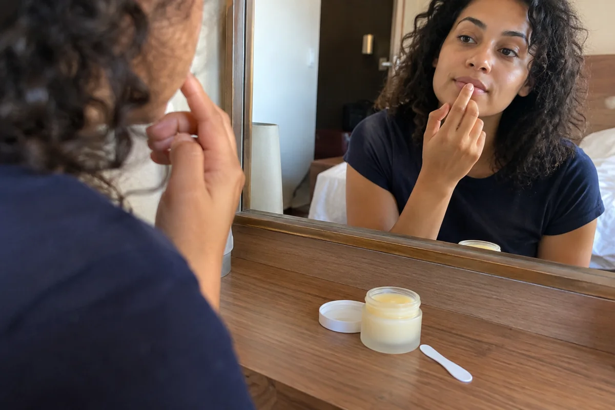 Application légère d’un baume devant le miroir