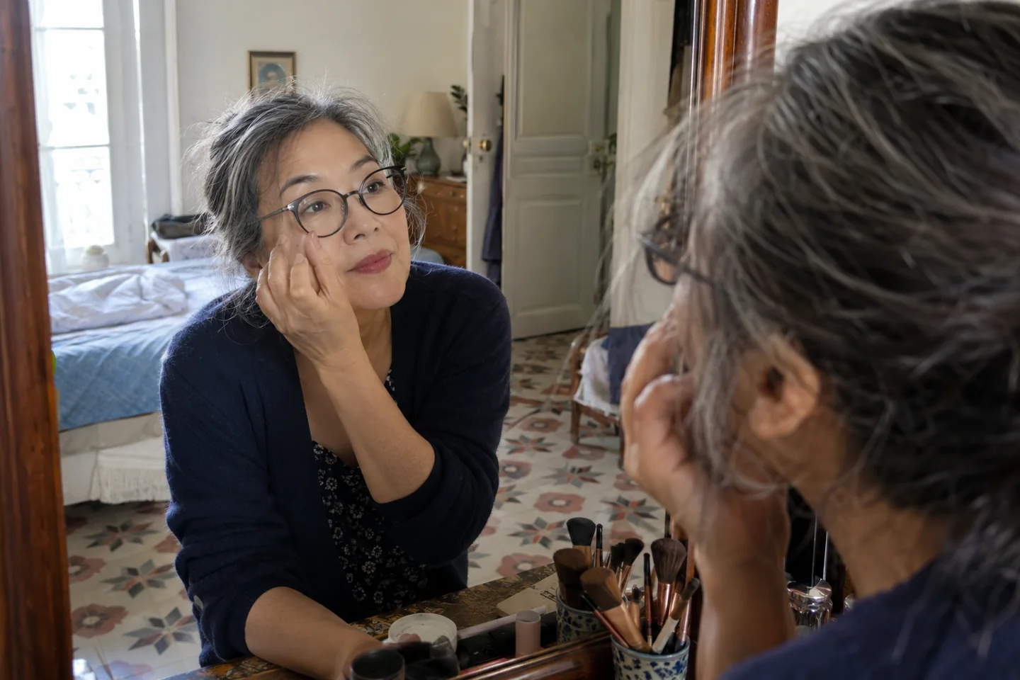 Une femme observe son maquillage avec ses lunettes