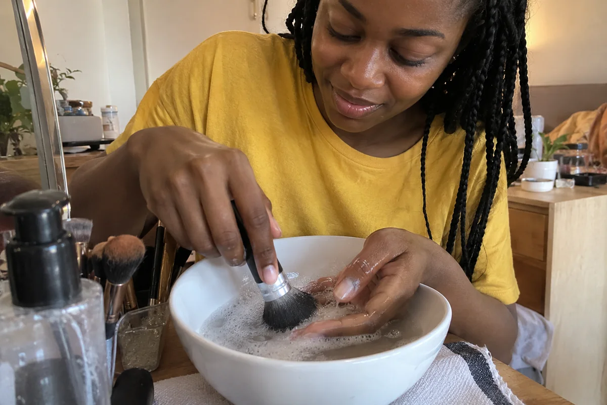 Nettoyage doux des poils d’un pinceau dans une eau savonneuse