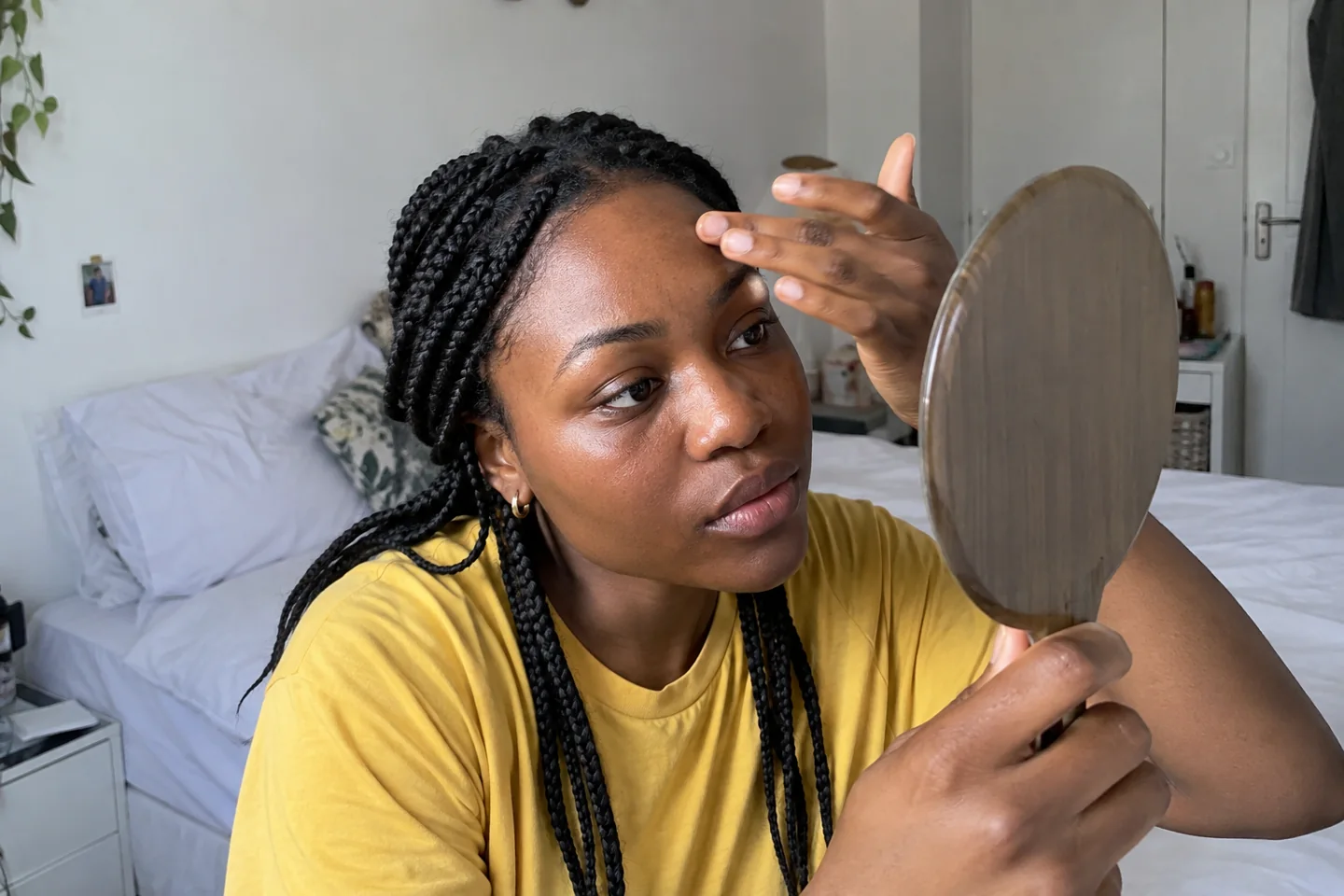 Une femme observe la brillance du front dans un miroir