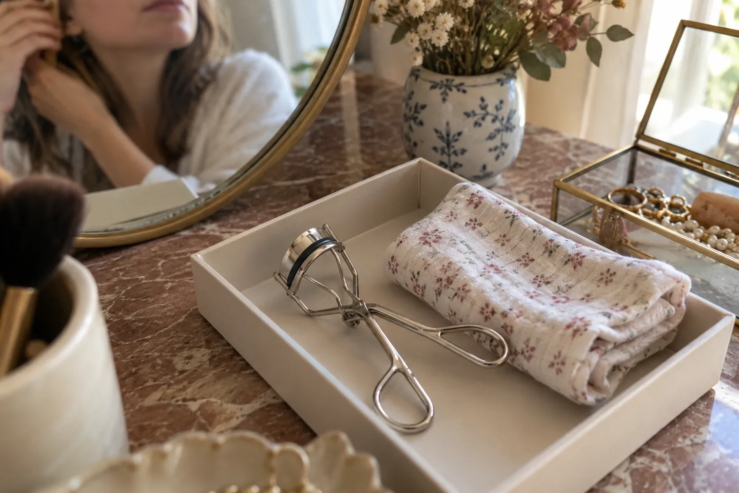 Recourbe-cils fermé rangé à plat dans une petite boîte ouverte et sèche.