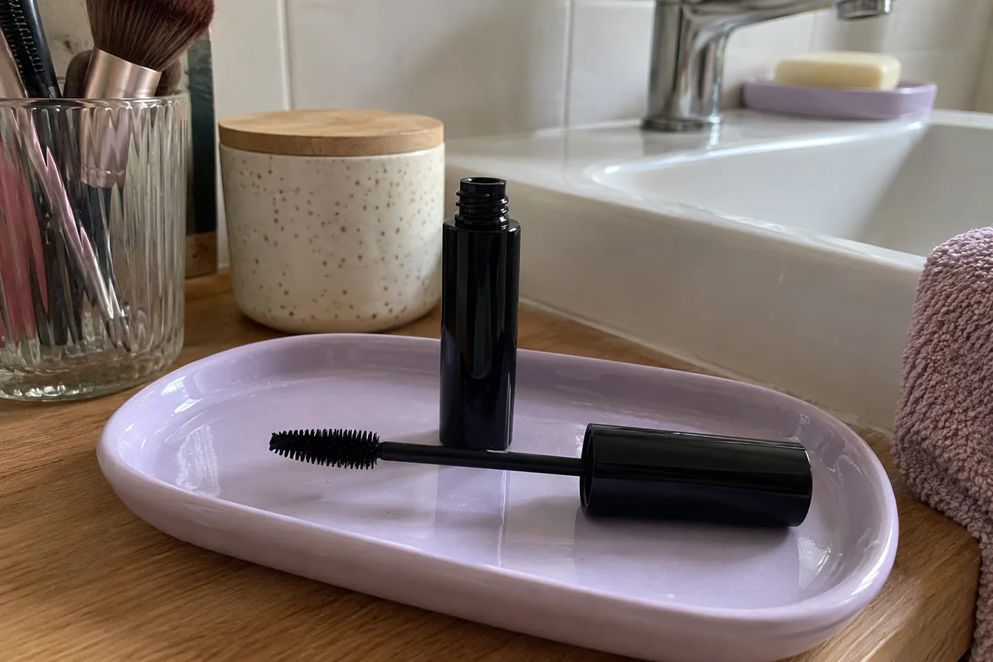 Une brosse générique de mascara et son flacon sur un plateau